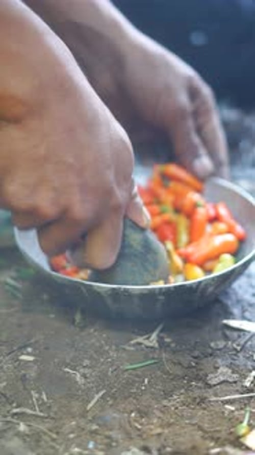 Hands Grinding Colorful Chilies with Pestle
