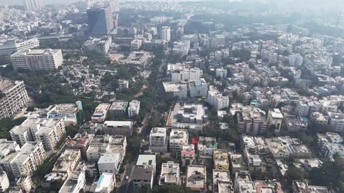 Daytime aerial view near Hussain Sagar, featuring dense residential blocks, commercial structures,