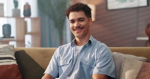 Man Smiling and Relaxing on Couch Indoors