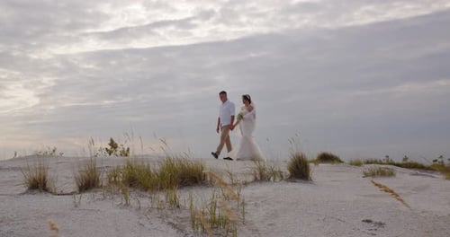 Newlyweds Walking Hand in Hand in Natural Landscape
