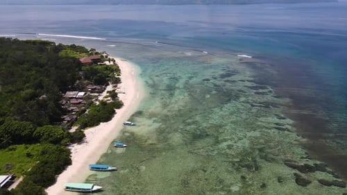 White Sand Beach And Tropical Island Surrounded By Bright Blue Sea In Bali, Indonesia During Summert