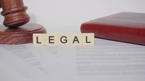 Gavel with Legal Text on White Desk