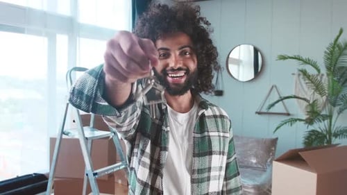 Young Man Smiling Holding Keys to New Home