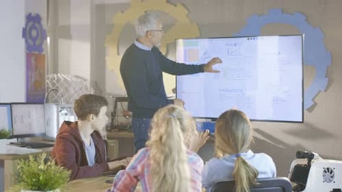 Le professeur explique la leçon à sa classe d'informatique. Il utilise Interactive Whiteboard.