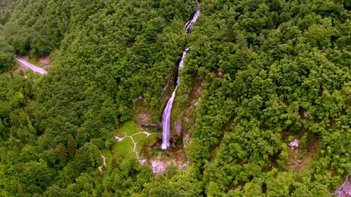 drone view of a valley in the alps mountains with a waterfall
