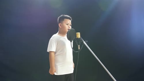 Young Child Singing into Microphone in Recording Studio