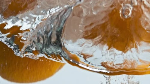 Fresh Oranges Falling Water Making Air Bubbles Closeup. Organic Tropical Juice. Beautiful