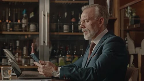 Middle Aged Businessman Working in Restaurant at Night