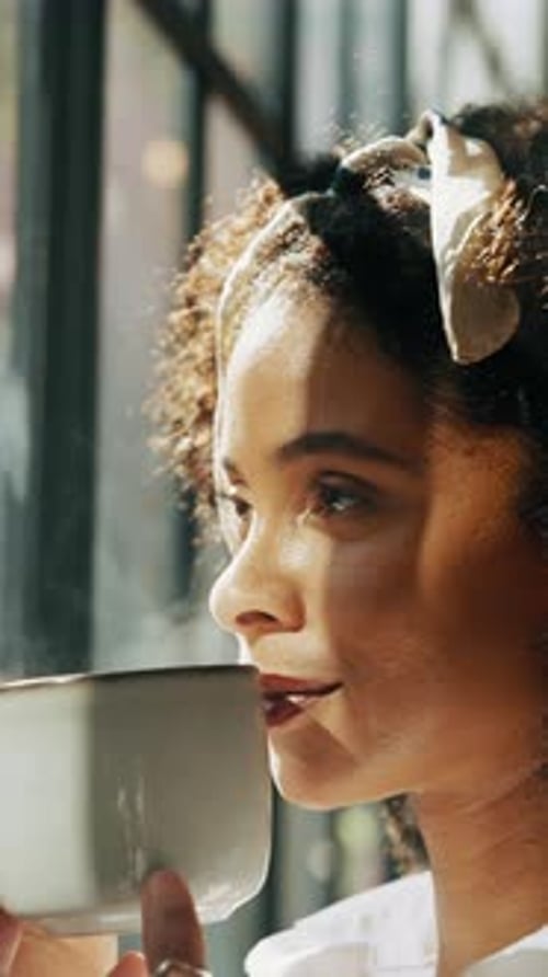 Woman Drinks from Cup in Sunlight