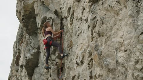 Woman Climbing Rock on Summer Day