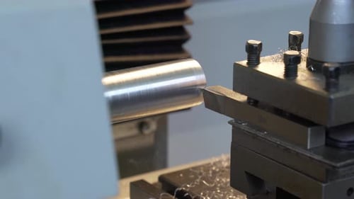 CNC Milling / Lathe Procesing a Piece of Metal. Metal Particles fall of. Close-up.