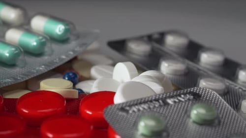 White medical pills, red and green capsules rotating in 4K. Pills, drugs, supplements, vitamins rota