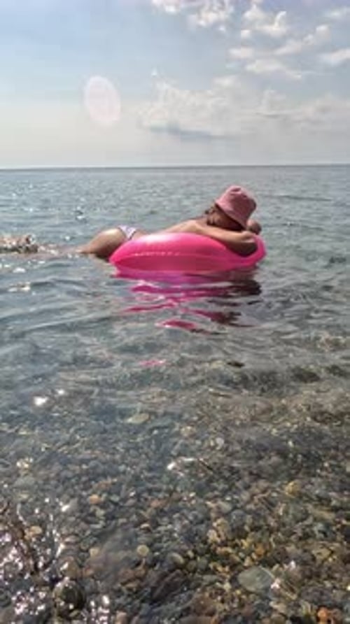 Summer Vacation Woman Floats on an Inflatable Donut Mattress a Water Toy Swim Ring Positive Happy