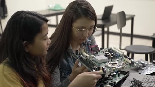 Teen Girls Examining Computer Motherboard in Classroom