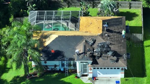 Construction Workers Removing Old Asphalt Shingles on Residential Private House Roof Rooftop Repair