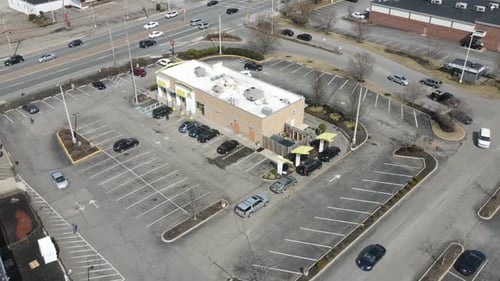 A hyperlapse of a busy McDonald's restaurant in an American suburb. Traffic. Mall. Drone static time