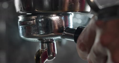 Macro of the hands of a barman while he is making coffee with the coffee machine, in a bar. Concep