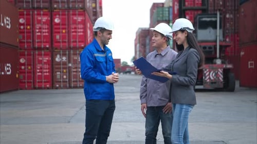 Container manufacturing manager and businesswomen survey the area to plan the storage