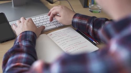 Ein Mann mit einer Behinderung, der im Rollstuhl sitzt, arbeitet am Computer