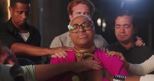 Group hands on a Woman in Prayer