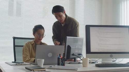 Two Coders Analyzing Idea while Developing New App Using Computer