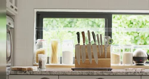 Empty house interior of kitchen with knifes in row on table