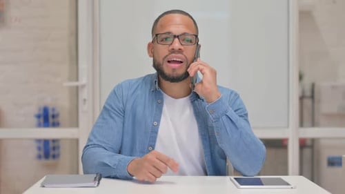 Man Talking on Smartphone in Bright Office