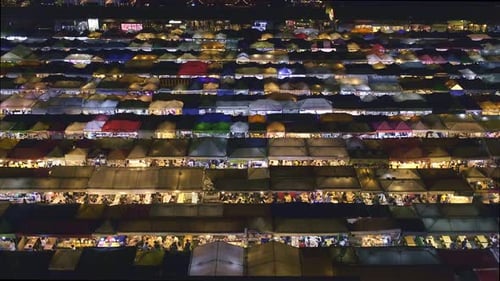 Tilting Over Rows of Colorful Market Tents and Food Stalls at Night