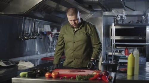 Chef Prepares Meat in Commercial Kitchen