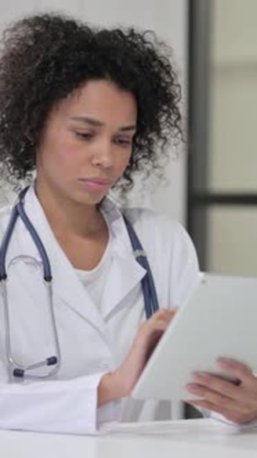 Focused Woman Doctor Using Tablet in Hospital Setting