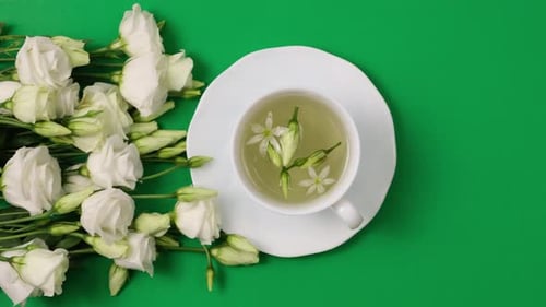 Flower Tea with White Roses on Green Background