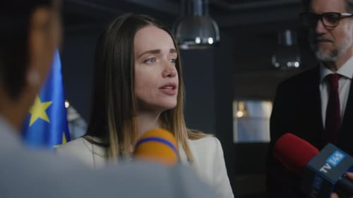 Woman Giving Press Conference with Microphones