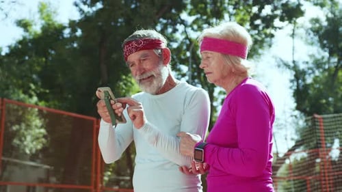 Active Senior Couple Celebrating with Smartphone