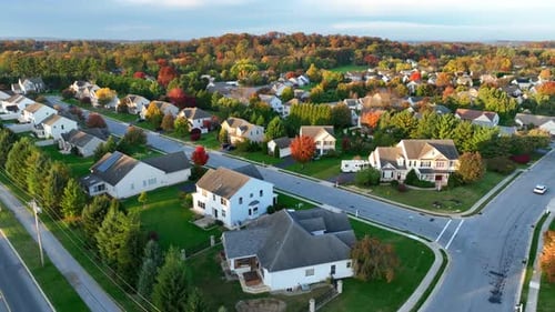 Residential street in autumn. Colorful fall foliage with American suburbia. Houses and homes along q