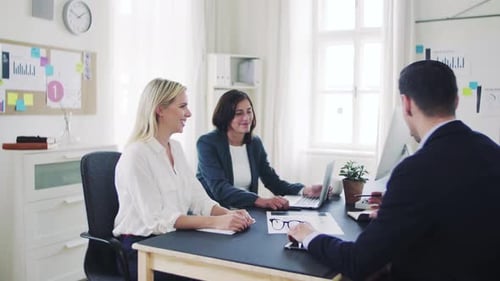 Diverse business team collaborating on laptop project in modern office space