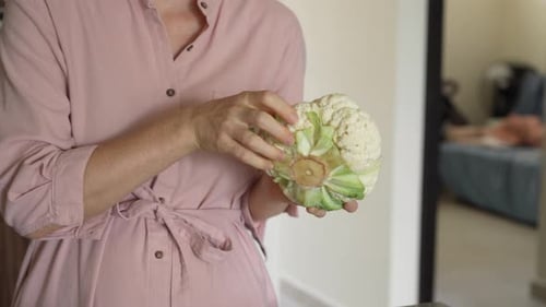 Woman Prepares Cauliflower in Kitchen