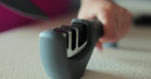 Sharpening a Knife with Gray Kitchen Sharpener