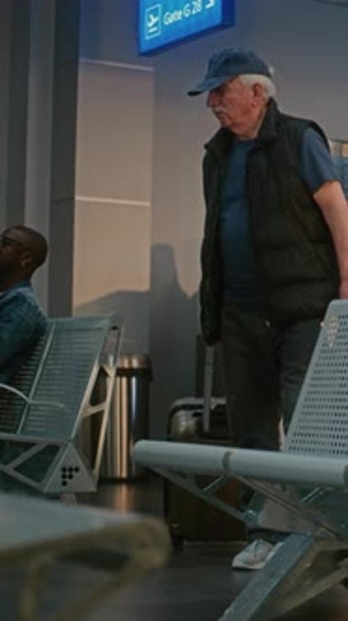 Airport Terminal Senior Man with Suitcase and Passport Sitting in Departure Hall After Security