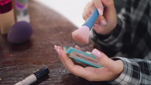 Closeup of Woman Applying Powder with Makeup Brush