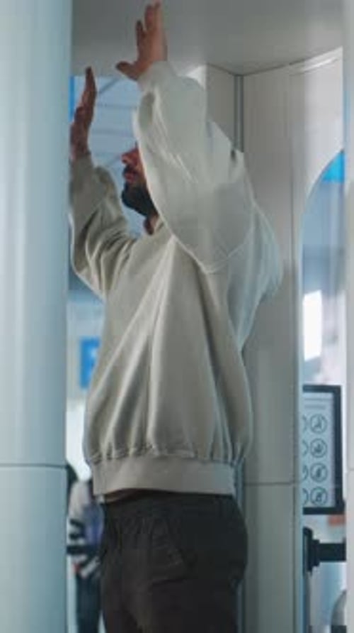 Security Checkpoint in Airport Security Officer Checks Adult Man for Plane Flight