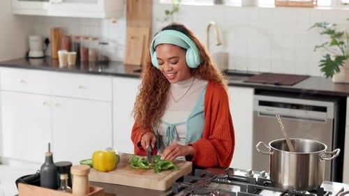 Happy Woman Cooking with Headphones in Modern Kitchen