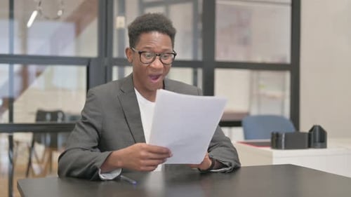 Young Adult Man Reads Documents and Celebrates