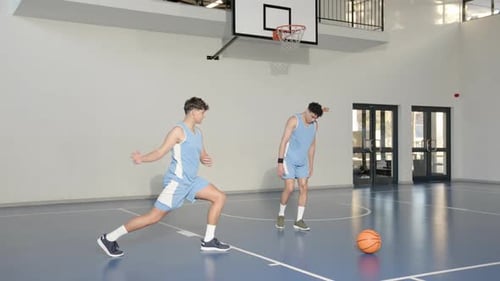 Basketball players stretching on court, preparing for practice session indoors
