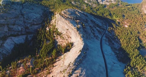 Autopista construida en medio de una montaña con curvas. Crece un bosque de pinos verdes