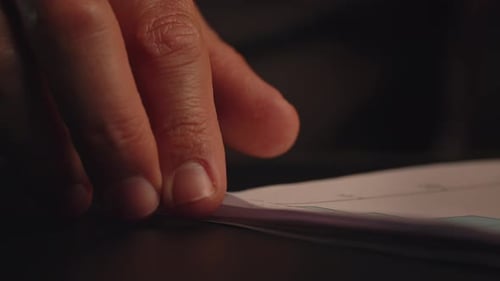 A Man's Hand Flips Through a Stack of Documents Male Businessman Looks Through Various Documents