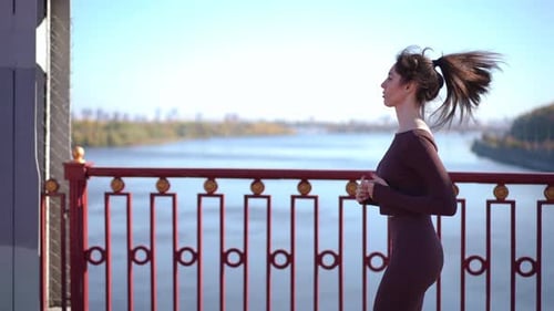 A Woman Jogging By the Beautiful River on a Bright and Sunny Day in Natures Embrace