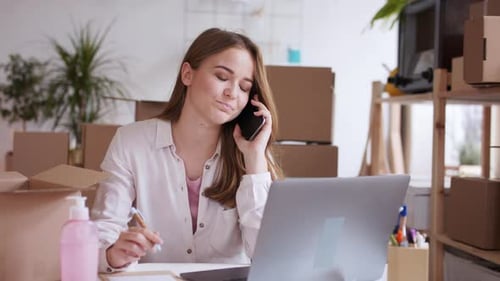 Woman Working at Desk Talking on Phone