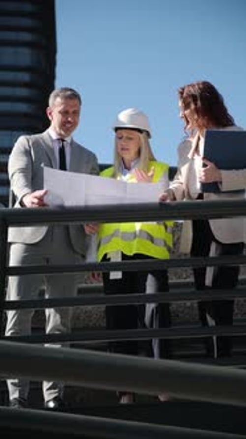 Business Team Inspects Blueprints on Site
