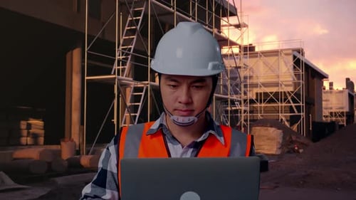 Close Up Of Asian Male Engineer Working On A Laptop At Building Site