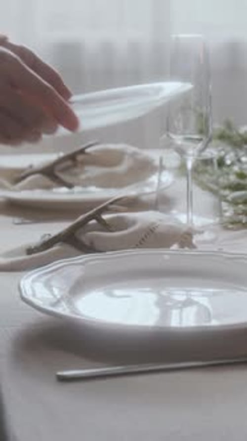 Hands of Woman Placing Plate and Elegant Cloth Napkin on Festive Dinner Table